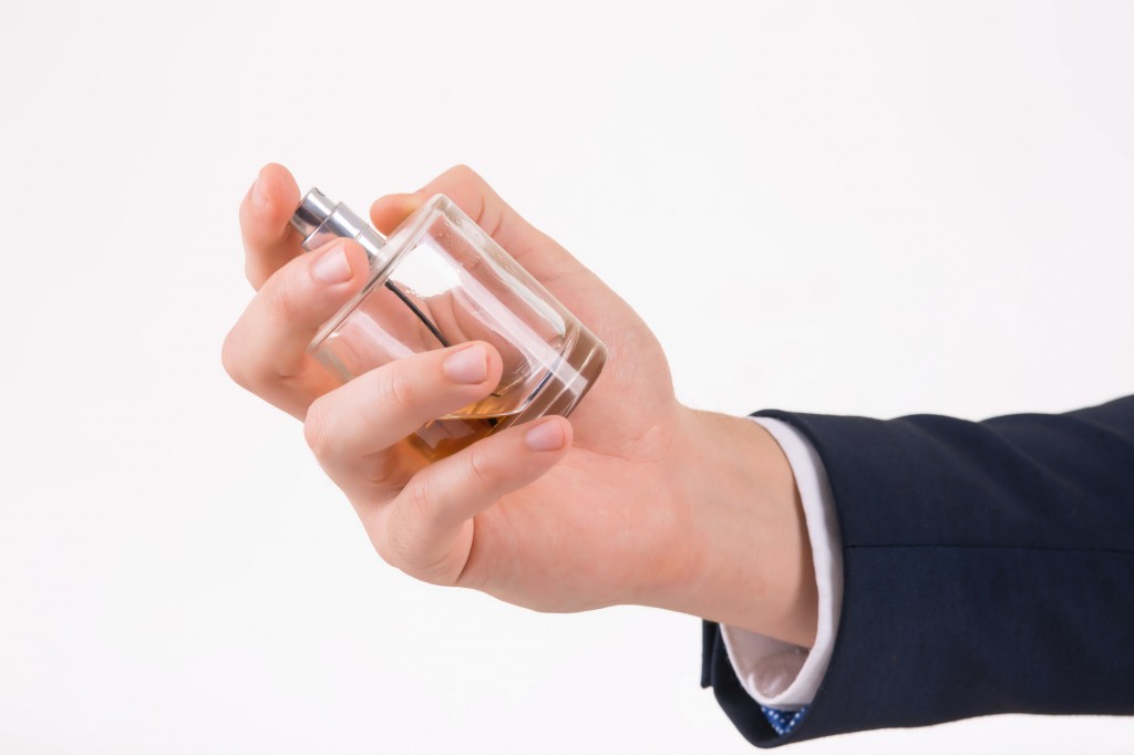 Male hand holding a perfume.