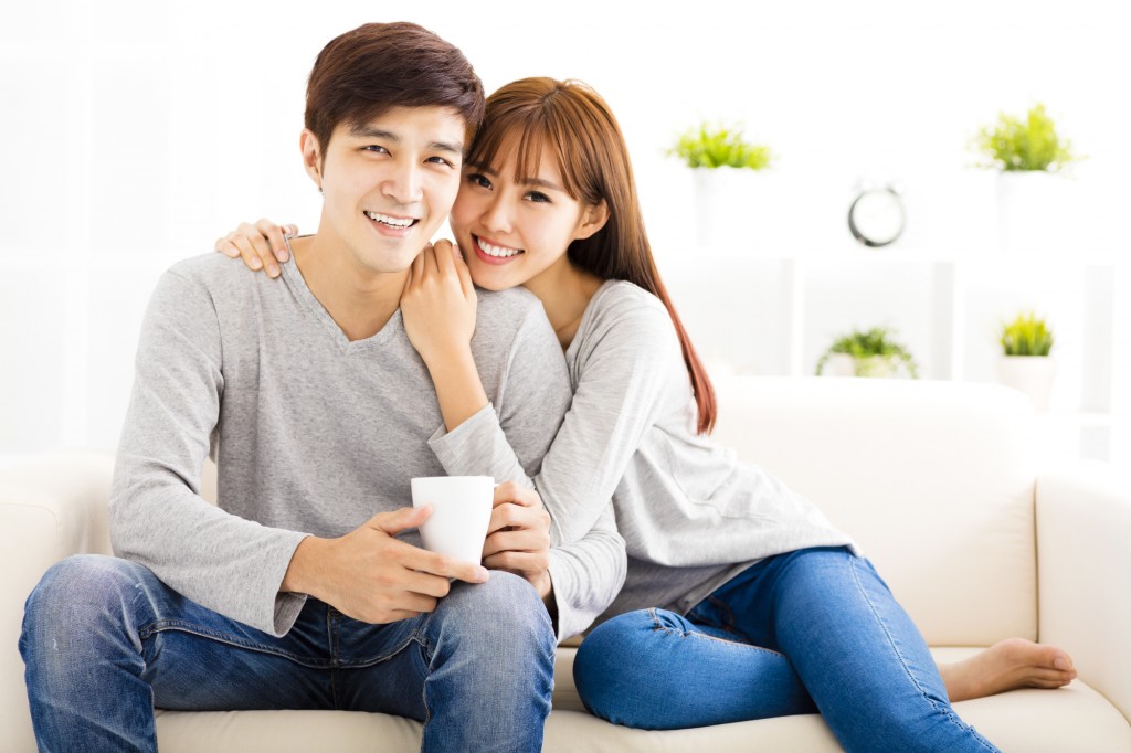 sweet young couple sitting in sofa